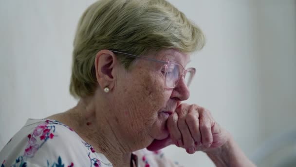 Starší žena v hluboké kontemplaci doma, autentické vylíčení problematiky stáří - Záběry, video