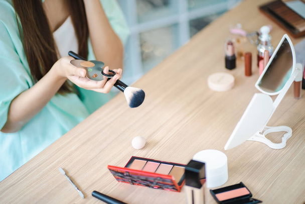 Beauty influencer ασιατικό κορίτσι makeup artist εφαρμογή σκόνη θεμέλιο με πινέλο. Ομορφιά influencer ασιατικό κορίτσι βίντεο σε απευθείας σύνδεση μάρκετινγκ ζωντανή μετάδοση  - Φωτογραφία, εικόνα