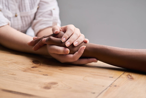 Ondersteuning, comfort en mensen die elkaars hand vasthouden voor empathie, liefde en vertrouwen. Hulp, tafel en diversiteit met een helpende hand van levenscoach, zorg voor vrienden en mededogen voor geestelijke gezondheid. - Foto, afbeelding