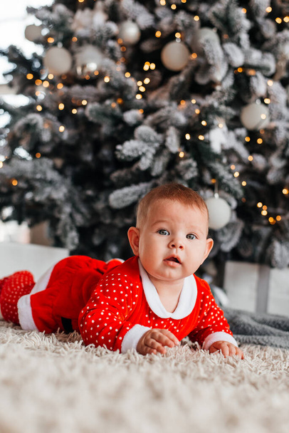 Baby on the background of a Christmas tree. - Fotoğraf, Görsel