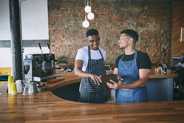 Ne všechna menu jsou z papíru. dva mladí muži pomocí digitální tablet při práci v kavárně - Fotografie, Obrázek