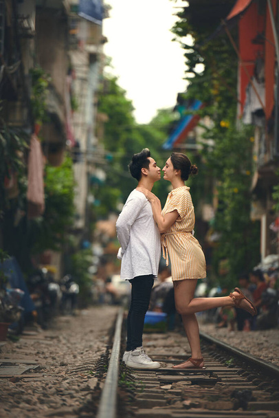 Se la vita ti regala il vero amore, considera te stesso fortunato. una giovane coppia che condivide un momento romantico sui binari dei treni per le strade del Vietnam - Foto, immagini