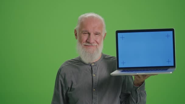Zelená obrazovka. Portrét usměvavého starého muže s notebookem s modrou obrazovkou a BTC mincí.Úspěch kariéry bohatství, investice do kryptoměny, hornictví.Bitcoin a budoucnost akumulovaných důchodů. - Záběry, video