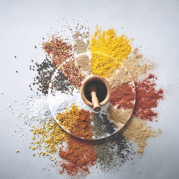 Itll taste as good as it looks. a pestle and mortar with an assortment of spices scattered around it - Фото, изображение
