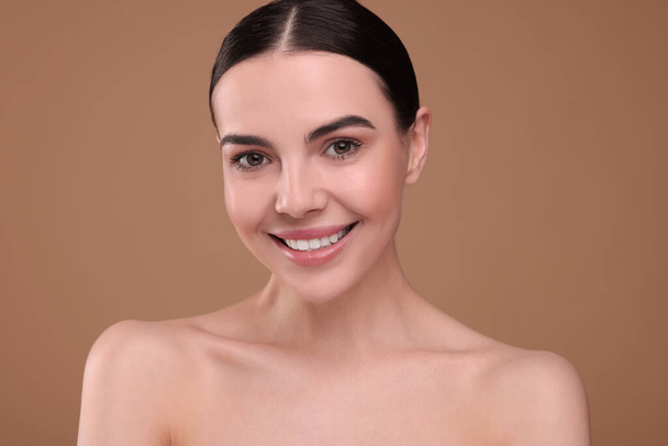 Beautiful woman with healthy skin on light brown background. Body Care - Foto, immagini