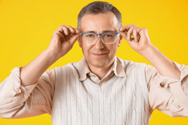 Reifer Mann mit Brille auf gelbem Hintergrund - Foto, Bild