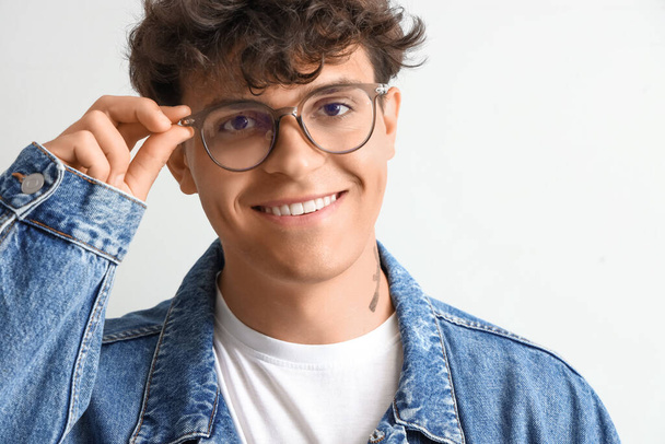 Young man in stylish eyeglasses on light background, closeup - Foto, afbeelding