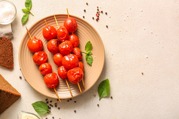 Bord van spiesen met smakelijke gegrilde tomaten en basilicum op witte achtergrond - Foto, afbeelding