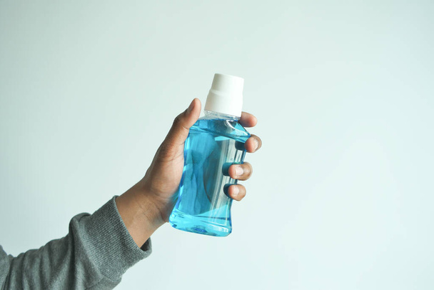  hand hold a mouthwash liquid container . - Photo, image