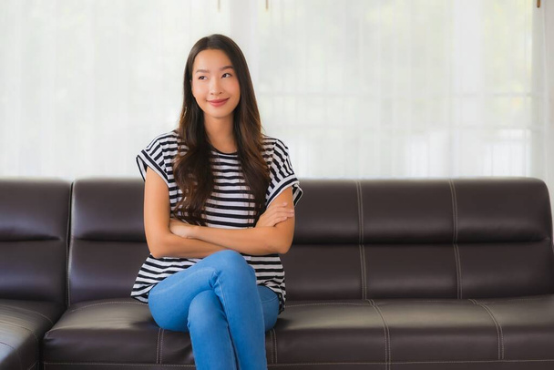 Porträt schöne junge asiatische Frau glücklich lächeln entspannen auf dem Sofa im Wohnzimmer Interieur - Foto, Bild