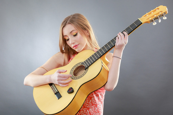una hermosa rubia joven con una guitarra clásica
 - Foto, imagen