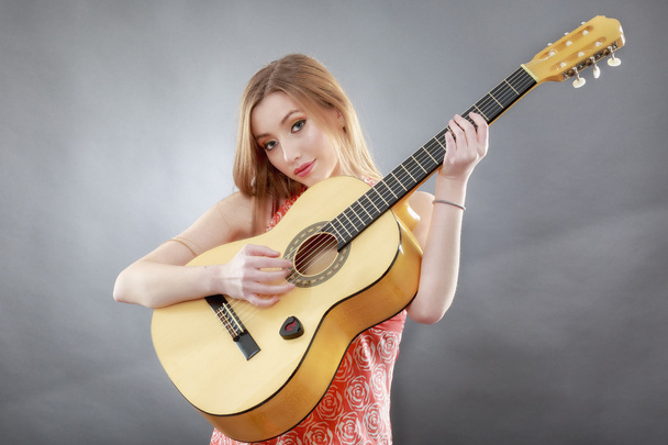 μια όμορφη νεαρή ξανθιά με μια κλασική κιθάρα - Φωτογραφία, εικόνα