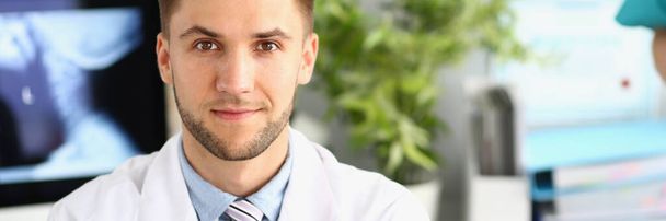 Portrait of young handsome male doctor in clinic. Medical services and insurance concept - Photo, Image