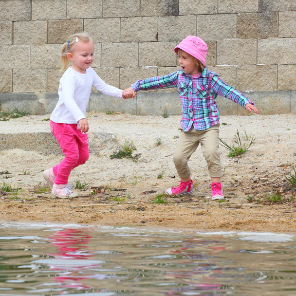 grappige kinderen spelen op het strand. - Foto, afbeelding