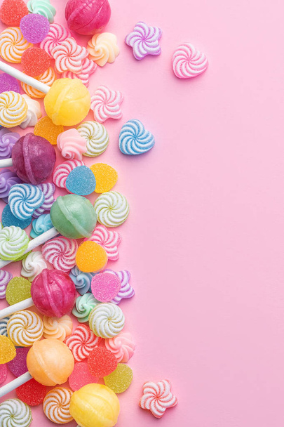 Colorful sweet lollipops and candies over pink background.  Flat lay, top view - Фото, изображение