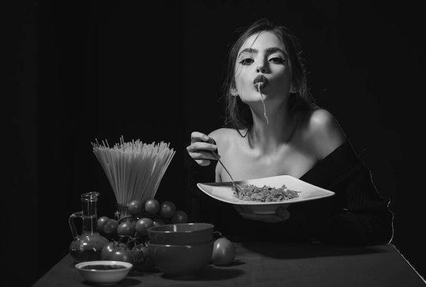 Sensuele vrouw eet spaghetti. Italiaans meisje eet spaghetti pasta - Foto, afbeelding