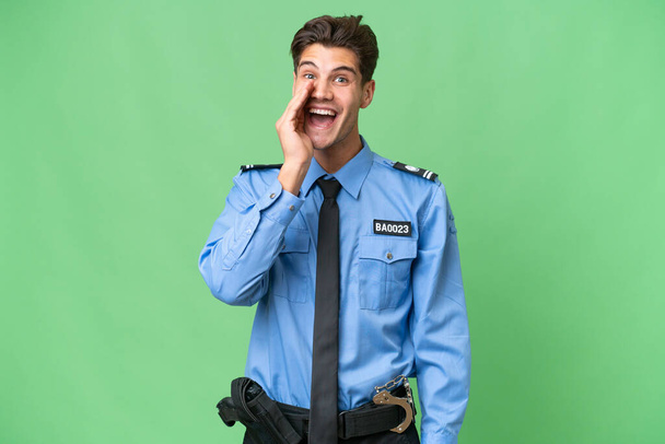 Молодой полицейский на изолированном фоне кричит с открытым ртом - Фото, изображение