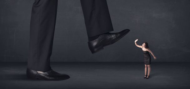 Giant person stepping on a little businesswoman concept - Photo, image