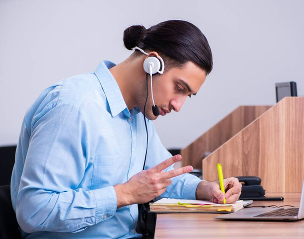 The call center operator working at his desk - Photo, Image