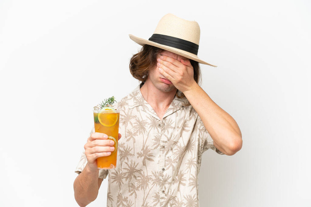 Giovane bell'uomo che tiene un cocktail isolato su sfondo bianco con espressione stanca e malata - Foto, immagini