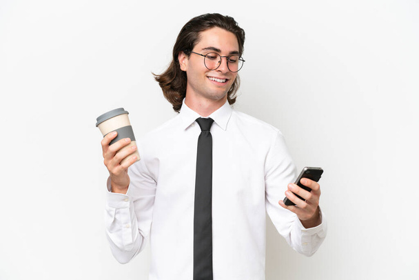Geschäft schöner Mann isoliert auf weißem Hintergrund hält Kaffee zum Mitnehmen und ein Handy - Foto, Bild