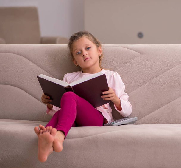 Kislány olvasás könyvet otthon - Fotó, kép