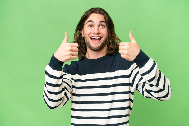 Young handsome man over isolated background giving a thumbs up gesture - Photo, Image