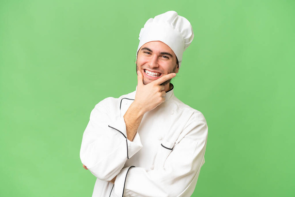 Giovane bel cuoco uomo su sfondo isolato sorridente - Foto, immagini