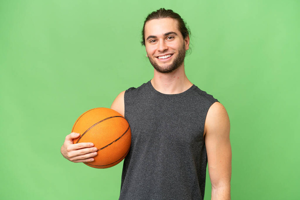 Молодий баскетболіст чоловік над ізольованим тлом, дивлячись збоку
 - Фото, зображення