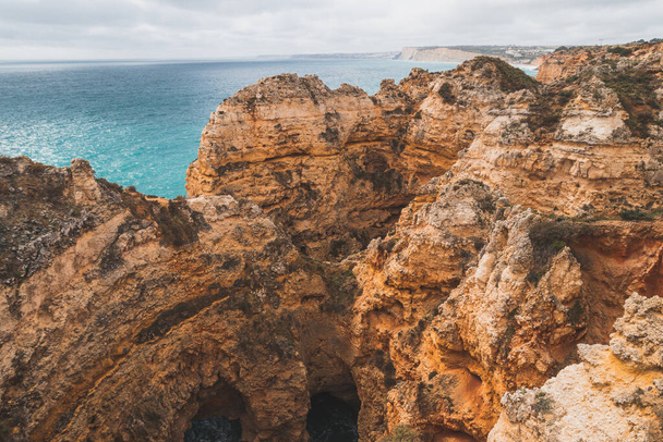 Famous tourist destination of Ponta da Piedade on the southern peninsula of Lagos in the Algarve region of Portugal. Cape of yellow-gold cliffs during the afternoon. - 写真・画像