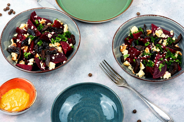 Salad of boiled beetroot, cheese, prunes and nuts. Healthy beet salad on gray background - Foto, Imagem