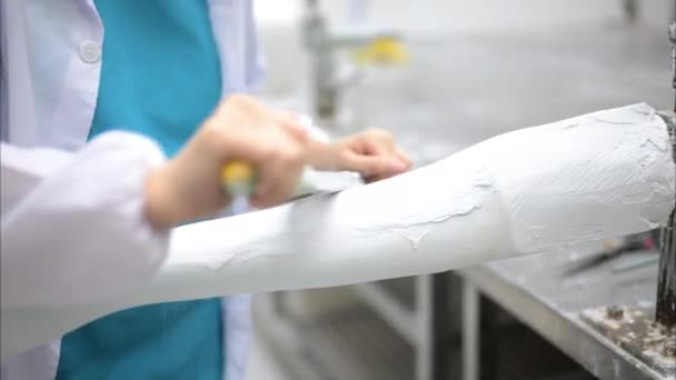 Technicien de prothèse sculptant plâtre coulé pour prise à l'usine de production de prothèses, Technologie de pointe à la fabrication de prothèses, Nouvelle production de membres artificiels pour les personnes handicapées - Séquence, vidéo