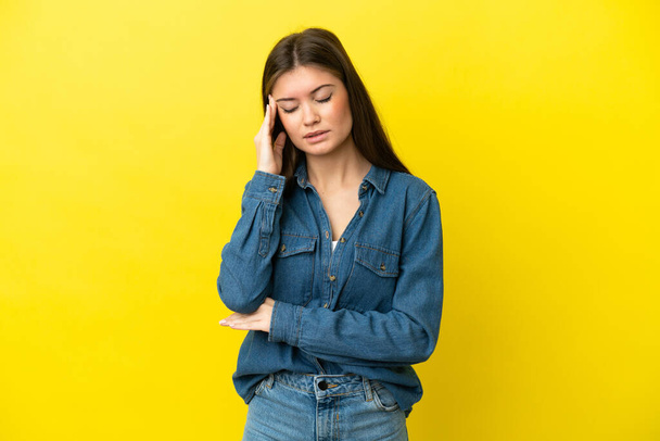 Young caucasian woman isolated on yellow background with headache - Photo, image