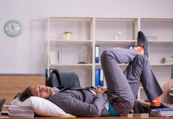 Young employee sleeping at workplace - Foto, Bild