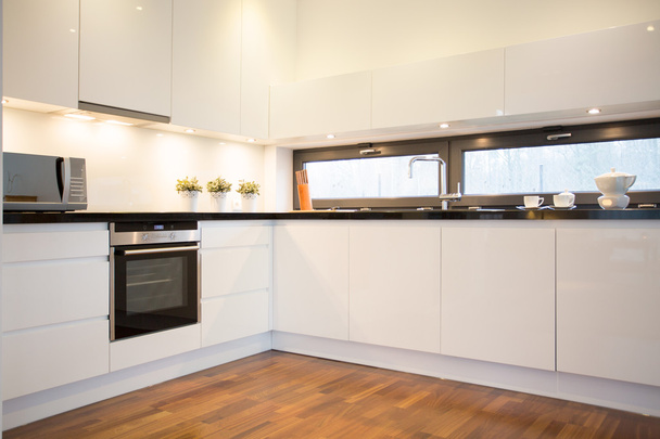 White kitchen with wooden floor - Фото, зображення