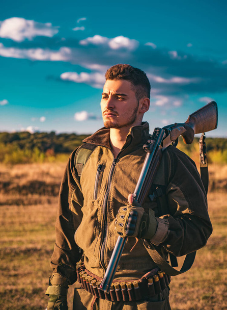 Hunter with shotgun gun on hunt. Cartridges shotgun. Track down. Close up Portrait of hamdsome Hunter - Photo, Image