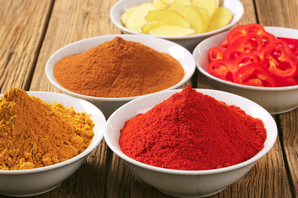 Currypulver, Paprika, gemahlener Zimt, geschnittene Ingwerwurzel und  - Foto, Bild