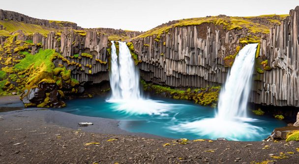 niesamowite i piękne wodospady spadające z góry w Islandzie na środku jeziora - Zdjęcie, obraz