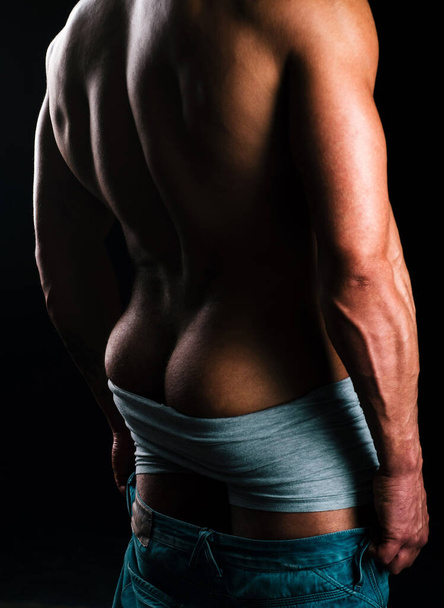 М'язистий атлетичний сексуальний чоловік з голим торсом. Сідниці чоловічі. М'язова спина
 - Фото, зображення