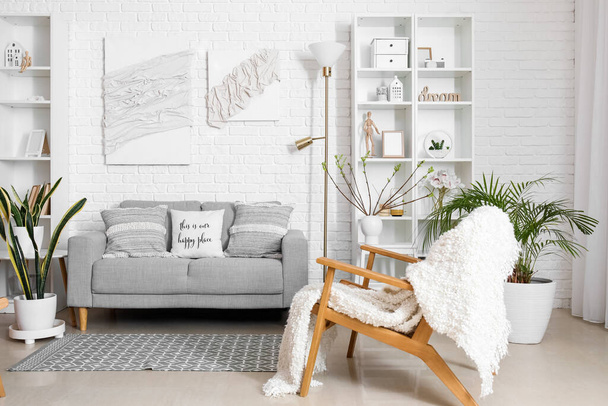 Stilvolles Interieur eines hellen Wohnzimmers mit gemütlichem Sofa und Postern - Foto, Bild