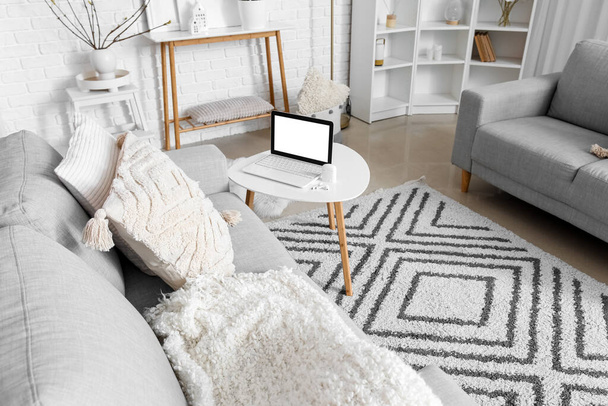 Interior elegante da sala de estar leve com laptop moderno na mesa - Foto, Imagem
