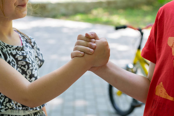 Kinderen die buiten elkaars hand vasthouden, communicatie- en vriendschapsconcept - Foto, afbeelding