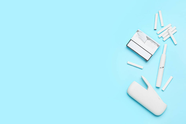 Современные электронные сигары, пачки и палочки на синем фоне - Фото, изображение