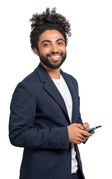 Portrait of cheerful young African American businessman in elegant suit holding smartphone isolated on white background. Concept of business communication - Valokuva, kuva
