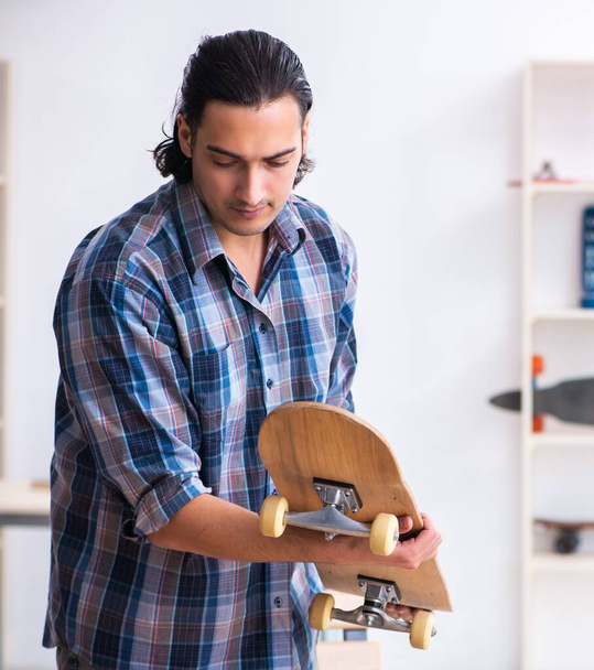Man repairing skateboard at workshop - Foto, Bild