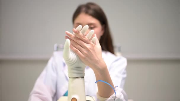 Technicien professionnel testant le bras bionique robotique à la fabrication de prothèses, Technicien vérifiant et contrôlant la main artificielle de prothèse, Technologie à la fabrication de prothèses - Séquence, vidéo