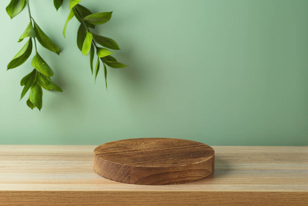 Pusta drewniana belka podium na stole nad zieloną ścianą z tłem liści. Mock do projektowania i wyświetlania produktu - Zdjęcie, obraz