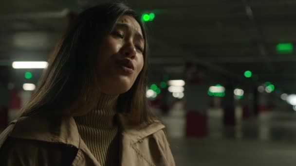 Zklamaný asijské žena dívka mluvit s někým v podzemí parkoviště smutný naštvaný číňan korejština japonská přítelkyně hádka s přítelem negativní konverzace řešit konflikt nedorozumění - Záběry, video