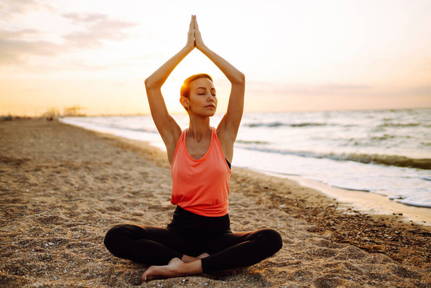 Portrait of young  woman do meditation around sea beach ocean at sunrise for health. Sport, Active life. - Zdjęcie, obraz