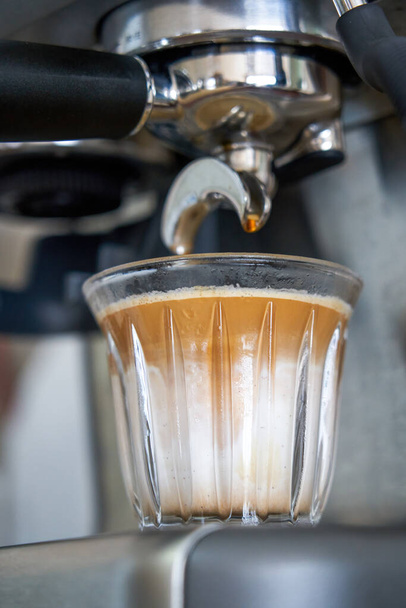 A barista is making a latte with an espresso machine - Фото, зображення